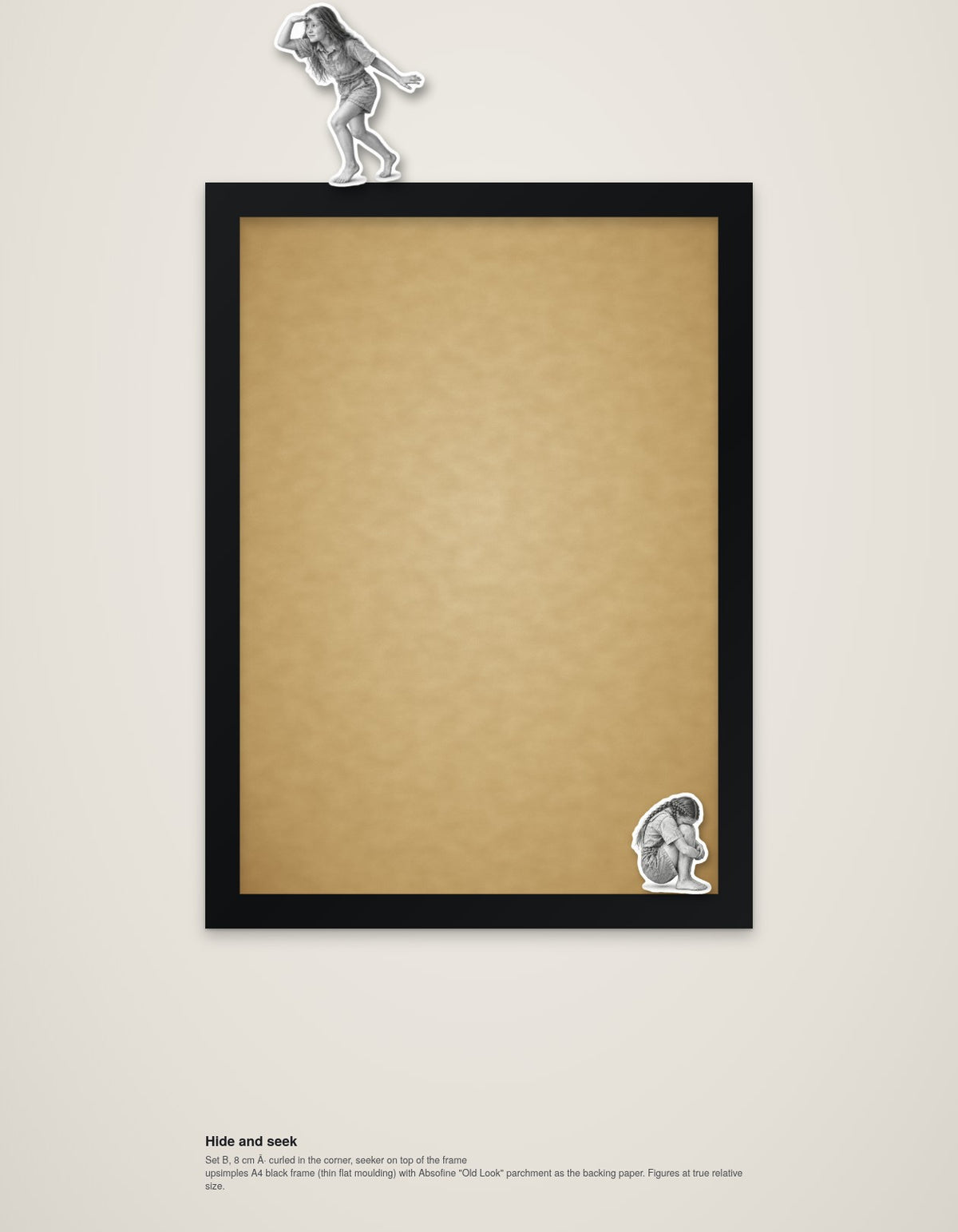 Hide and Seek – framed wall art with two wooden figures, one hiding, one on top of the frame (A4)